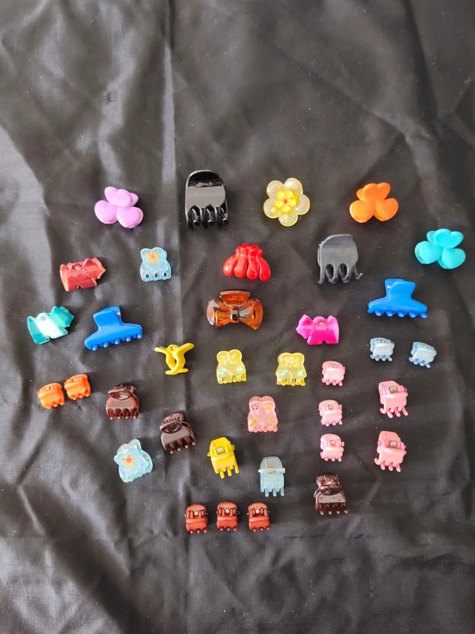 Conjunto de mini molas para cabelo com diversos formatos e cores.